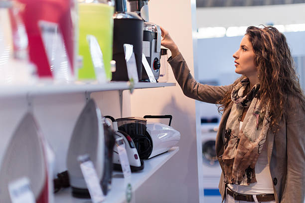 Choosing electric juicer Beautiful woman choosing new electric juicer in homeware store electrical equipment stock pictures, royalty-free photos & images