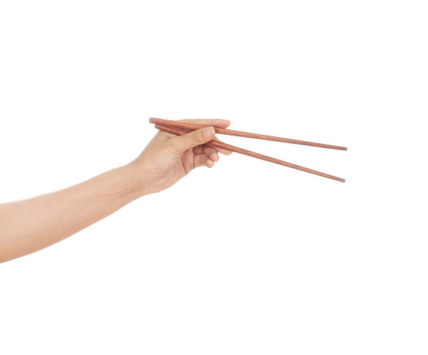 Chopsticks in a hand Chopsticks in a hand isolated on white background chopsticks stock pictures, royalty-free photos & images