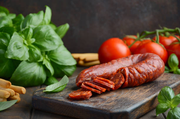chorizo worst. spaanse traditionele chorizo worst met verse kruiden en tomaten. - chorizo stockfoto's en -beelden