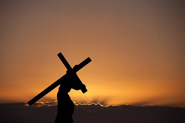 un homme au coucher du soleil avec un cross. - good friday photos et images de collection