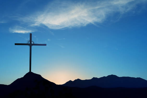 croix chrétienne sur un paysage bleu de fond de coucher de soleil - good friday photos et images de collection