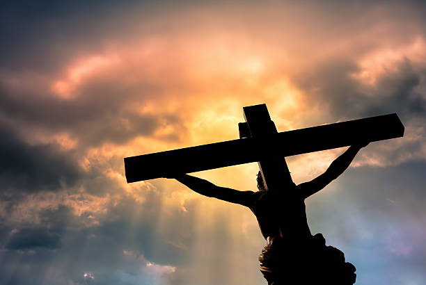 Christian cross with Jesus Christ statue over stormy clouds Jesus Christ Son of God over dramatic sky background religion and spirituality concept cross shape photos stock pictures, royalty-free photos & images