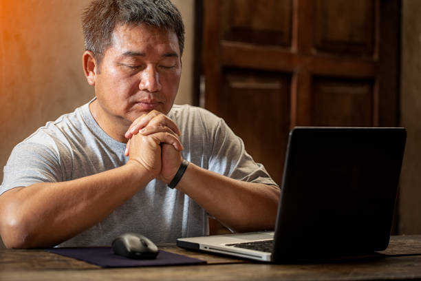Christian men praying and working at home stock photo