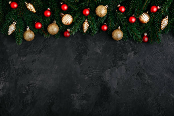 Christmas background with green fir branches, cones and golden and red decor. stock photo