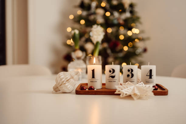 Christmas candle lights first advent Advent Sunday on table indoors infront of christmas tree firsta advent stock photo