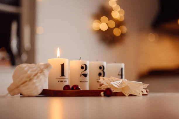 Christmas candle lights first advent Advent Sunday on table indoors infront of christmas tree firsta advent stock photo