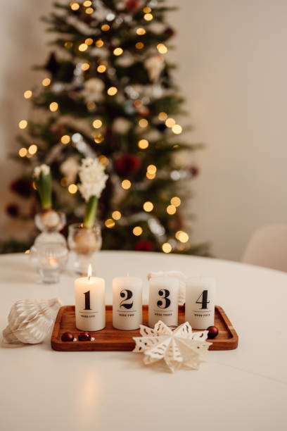 weihnachtskerzenlicht ersten advents-adventssonntag auf tisch drinnen vor demweihnachtsbaum firsta advent - erster advent stock-fotos und bilder