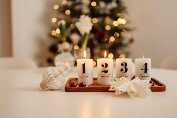 Christmas candle lights second advent on table indoors infront of christmas tree andra advent stock photo