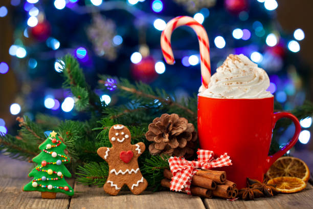 Christmas cappuccino and gingerbread cookies infront Christmas tree stock photo
