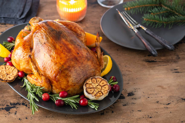 Christmas chicken with thyme and cranberries on a wooden table. Christmas atmosphere. stock photo
