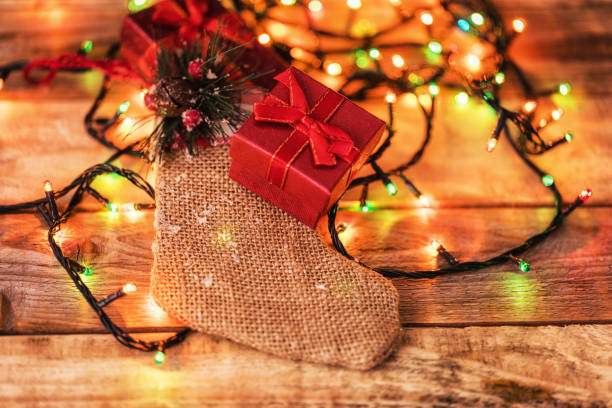Christmas decoration arrangement, led lights, santa boot shaped gift bag and giftboxes stock photo