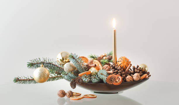 Christmas Decoration in a Brown Container Christmas decoration with fir branches, candle, pine cone, dried oranges and Christmas balls in a brown container centerpiece stock pictures, royalty-free photos & images