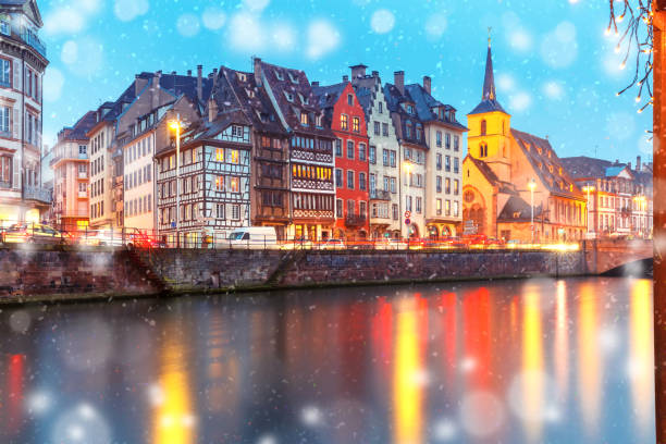 Christmas embankment in Strasbourg, Alsace Picturesque Christmas quay and church of Saint Nicolas with mirror reflections in the river Ile during evening blue hour, Strasbourg, Alsace, France strasbourg stock pictures, royalty-free photos & images