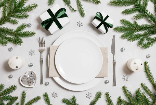 Christmas empty table setting with silver decor and fir branches on gray background. View from above. Space for text. stock photo