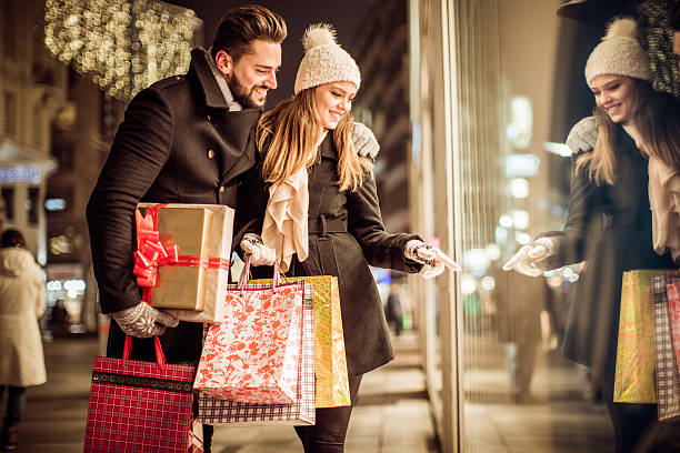 christmas gift shopping - woman holding a christmas gift imagens e fotografias de stock