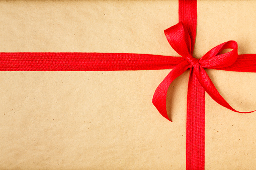 christmas gift with recycled wrapping paper and red bow