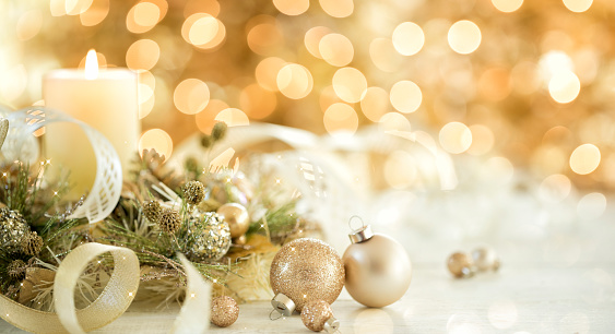 Christmas Elegant Gold Candle and Ornaments against a Golden Lights Christmas Tree Background