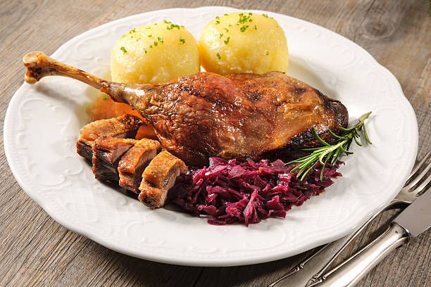 Christmas goose Crusty goose leg with braised red cabbage and dumplings goose meat photos stock pictures, royalty-free photos & images