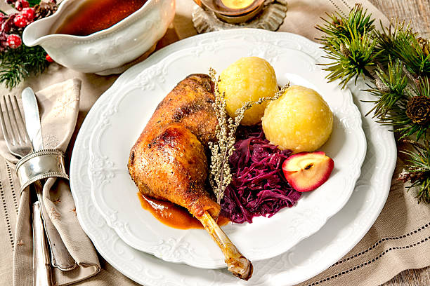 Christmas goose Crusty Christmas goose leg with braised red cabbage and dumplings goose meat photos stock pictures, royalty-free photos & images