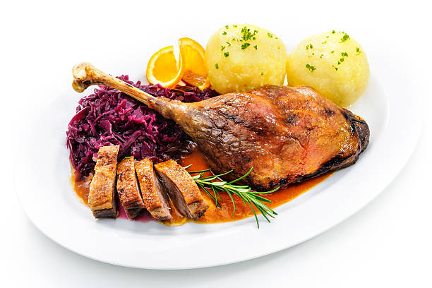 Christmas goose Crusty goose leg with braised red cabbage and dumplings isolated on white goose meat photos stock pictures, royalty-free photos & images