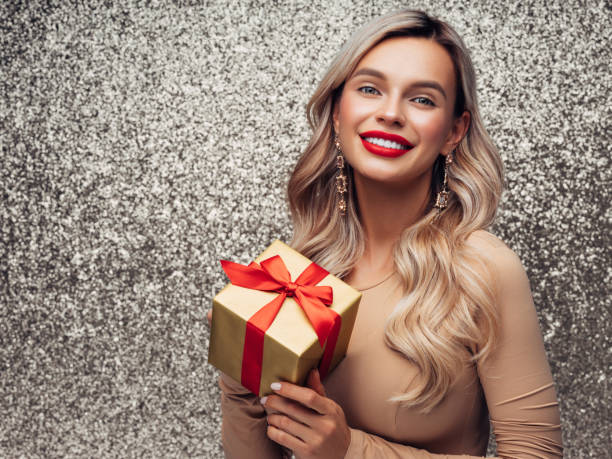 Weihnachten glücklich lächelnde junge Frau hält Geschenkbox in Händen