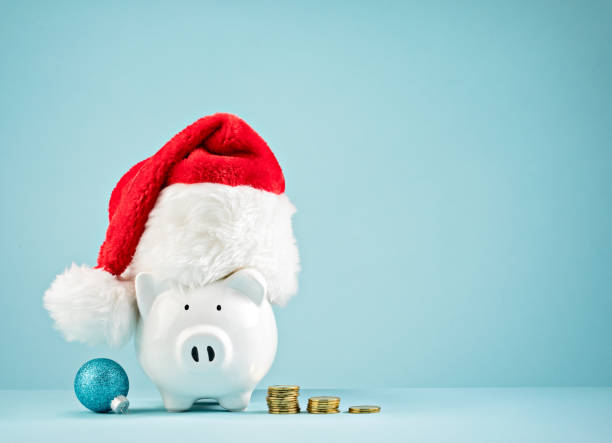 Christmas Holiday piggy bank wearing santa hat stock photo