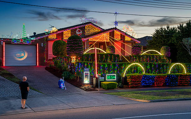 Christmas House - Allumba Drive, St Helena, Melbourne Melbourne, Australia - December 7, 2016: A homeowner stands outside his house, located at 24 Allumba Drive, Saint Helena, which has been colourfully decorated with lights for Christmas. melbourne street stock pictures, royalty-free photos & images