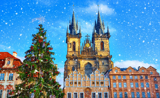 Christmas in Prague, Czech Republic Christmas in Prague, Czech Republic. Green christmas tree at central square old town (Staromestska) in front of Church of Our Lady Before Tyn. Snowfall, snow in sunny holiday winter day. prague old town square stock pictures, royalty-free photos & images