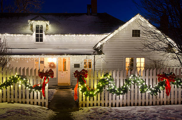 Christmas Lights on a Farm House "An old ranch house, complete with white picket fence, is decked out in Christmas lights, ribbons and garlands.  A Christmas tree in the window sets the scene for a romantic country Christmas.  There is copy space available for your own holiday message." christmas lights house stock pictures, royalty-free photos & images