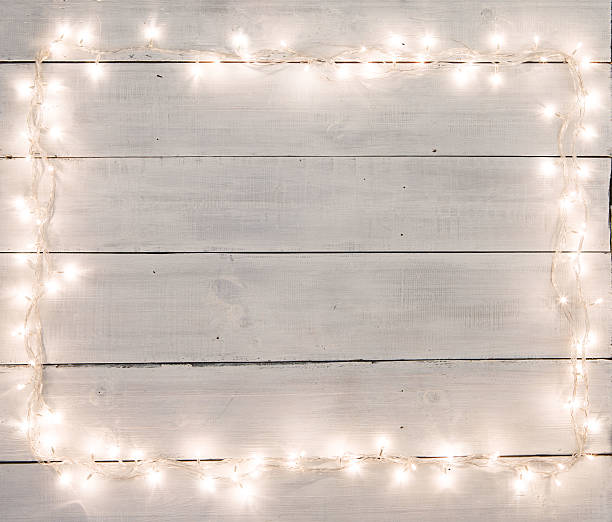 Christmas lights on white painted wooden background with copy sp stock photo