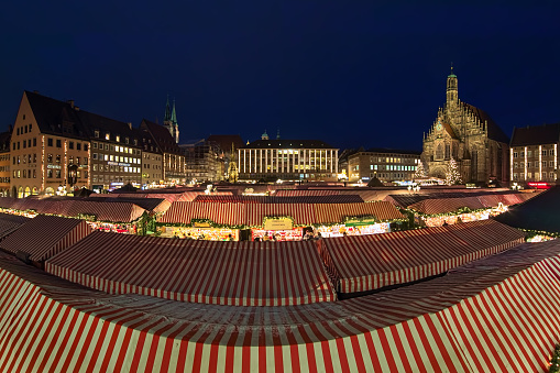 Nuremberg, Germany - December 13, 2017: Christkindlesmarkt Christmas market at Hauptmarkt platz (Main Market Square) in dusk. This is one of the largest Christmas markets in Germany and one of the most famous in the world. The market started back in the 17th century.