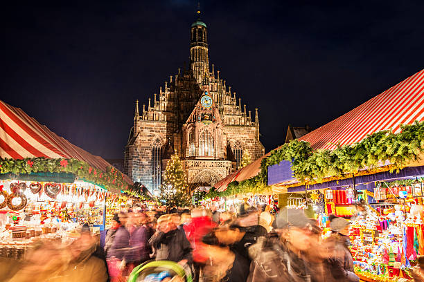 Christmas Market Nuremberg (Nuremberg Christkindlesmarkt) Huge crowd of people moving over Nuremberg´s world-famous christmas market (Christkindlsmarkt) at night, passing colorful illuminated christmas decoration and food stalls. Nuremberg´s landmark Frauenkirche (Church of our Lady) can be seen in the back. bavaria stock pictures, royalty-free photos & images