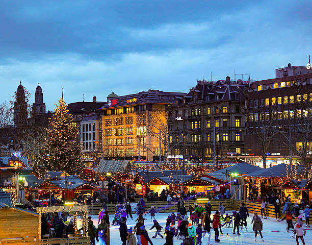 Christmas market zuerich city iceskating christmas market in zuerich at dawn. market huts and an icefield for iceskating. picture taken from the opera house in december 2015. In the background is the typical skyline of zuerich. zurich stock pictures, royalty-free photos & images