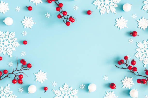 christmas or winter composition. snowflakes and red berries on blue background. christmas, winter, new year concept. flat lay, top view, copy space - composição imagens e fotografias de stock