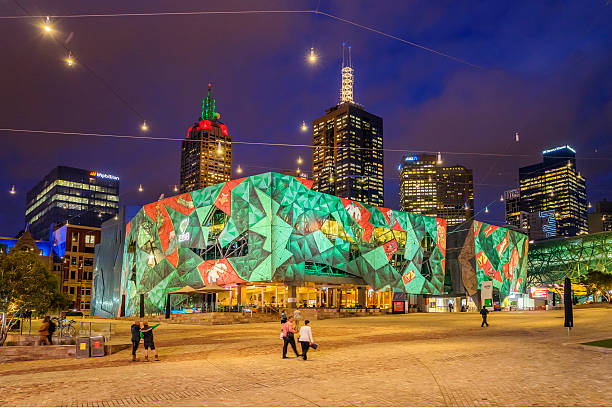 Christmas projections at Federation Square, Melbourne Melbourne, Australia - December 14, 2016: Visitors around Federation Square. A building has a Christmas design projected on its facade to commemorate the upcoming holiday. federation square stock pictures, royalty-free photos & images
