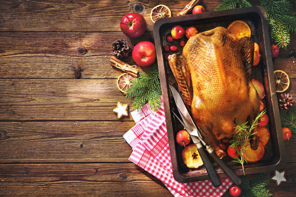 Christmas roast duck with apples and oranges on baking tray Roast duck with apples and oranges on baking tray. Cooking at Christmas time goose meat photos stock pictures, royalty-free photos & images