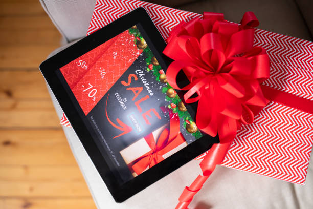 Digital tablet with Christmas sale website and Christmas present.