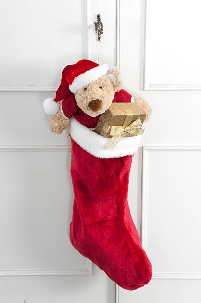christmas sock with teddy bear and gifts stock photo
