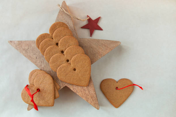 Christmas still life with gingerbread heart shaped cookies on a wooden star stock photo