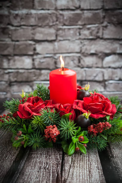 Christmas table decoration with burning red candle Christmas table decoration with burning red candle centerpiece stock pictures, royalty-free photos & images