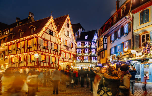 Christmas time in Colmar, Alsace, France Old town illuminated and decorate magical like a fairy tale in Noel festive season. People togetherness and happiness enjoying Christmas markets in Colmar, Alsace, France. riquewihr stock pictures, royalty-free photos & images