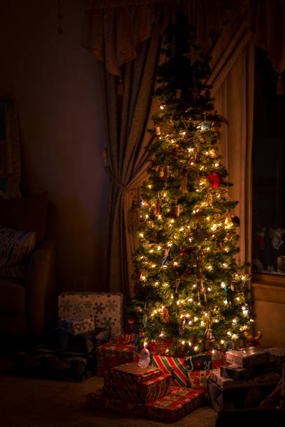 Christmas tree decorated and lit up in a home stock photo