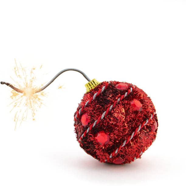 Christmas tree decoration. Red bomb ready to go off with golden sparkles on white background. New Year concept Christmas tree decoration. Red bomb ready to go off with golden sparkles on white background. New Year concept. firework explosive material stock pictures, royalty-free photos & images