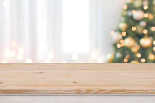 albero di natale sfondo sfocato con tavolo di legno di fronte - christmas table foto e immagini stock