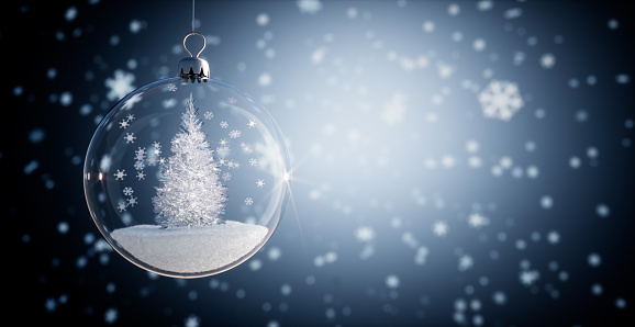Christmas tree inside glass Christmas Ball with dark blue background with falling snow flakes or ice crystals
