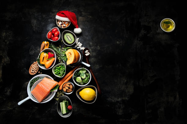 Christmas tree made from healthy food Christmas tree made of healthy food on black background. Top view with copy space. salmon seafood photos stock pictures, royalty-free photos & images