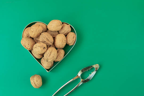 Christmas walnut shells and nutcracker on green background stock photo