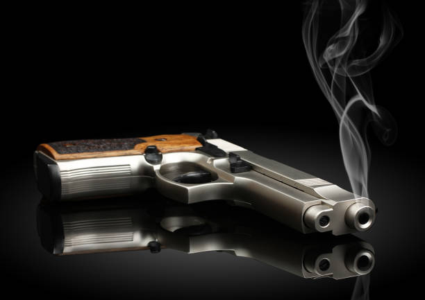 Chromed handgun on black background with smoke  Smoking Kills stock pictures, royalty-free photos & images