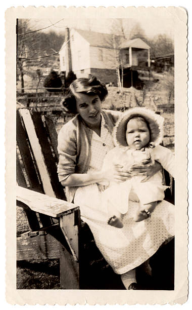 Chunky baby An old family photo of a mother holding her baby with the house in the background. farm photos stock pictures, royalty-free photos & images