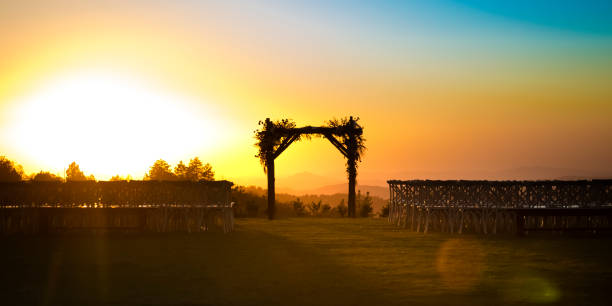 Chuppah silhouetted by the golden setting sun Chuppah silhouetted by the golden setting sun. Jewish wedding set up with rows of chairs and Chuppah in the center. It has a beautiful view of a golden setting sun in the horizon. chupah stock pictures, royalty-free photos & images
